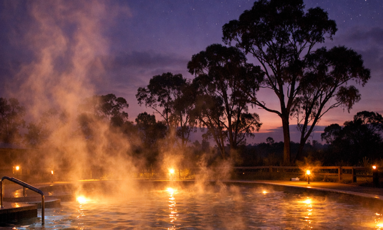Moree Artesian Aquatic Centre hot springs at dusk with steam rising into twilight sky