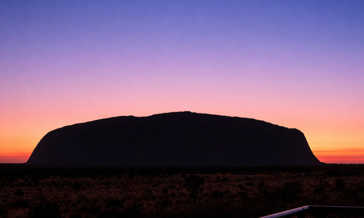 Sunrise at Uluru showing the monolith silhouetted against colourful dawn sky in Red Centre