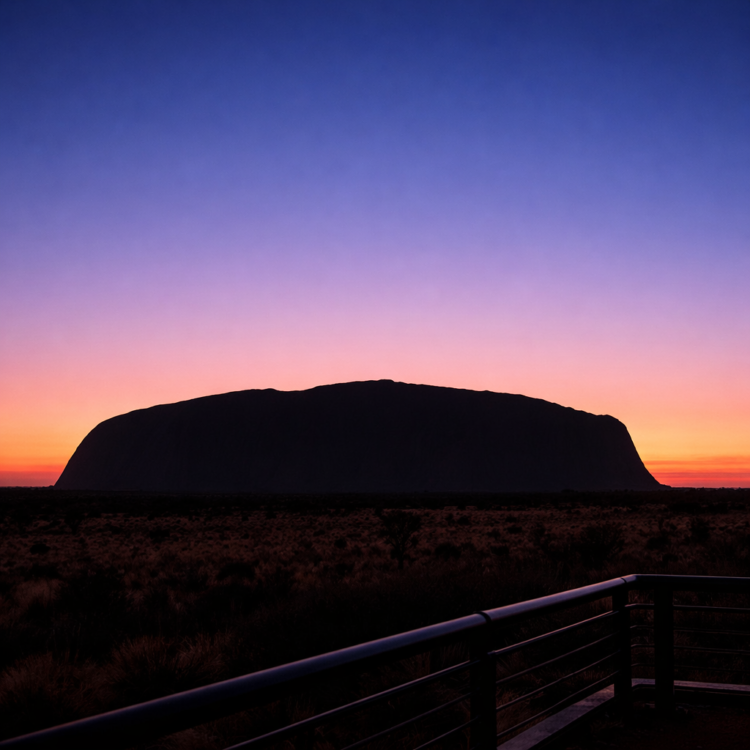 Sunrise at Uluru showing the monolith silhouetted against colourful dawn sky in Red Centre