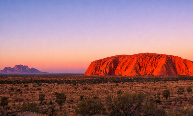 Sunrise at Uluru viewing platform showing the rock glowing orange at dawn in the Red Centre