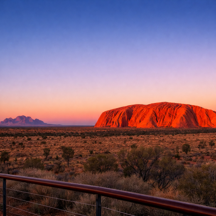 Sunrise at Uluru viewing platform showing the rock glowing orange at dawn in the Red Centre