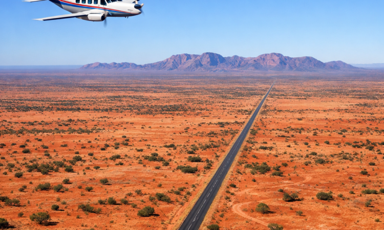 Aerial view of plane flying over vast Australian outback highlighting travel distances between destinations